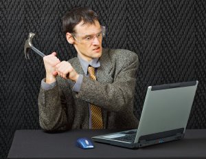 Businessman about to crush laptop with hammer