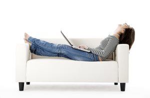 Woman-stretched-out-on-couch-on-laptop