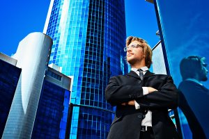 Young business man standing in the big city and purposefully looking away
