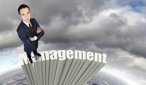 businessman in suit standing on word Management