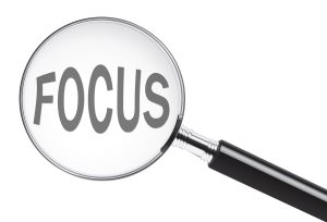 Focus concept with text under a magnifying glass