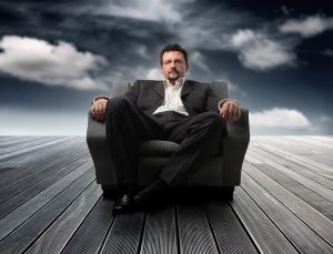 business man sitting on an armchair against a sky