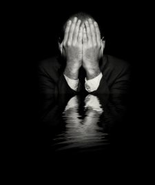 Businessman with hands covering eyes