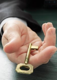 hand offering the golden key to success