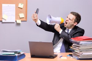 Angry Businessman shouting into microphone