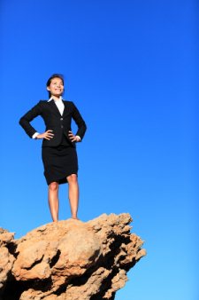 Businesswoman standing on mountain cliff