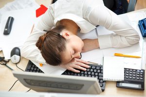 Woman asleep on laptop at desk