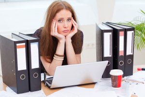 Woman in bad mood in the office because its boring
