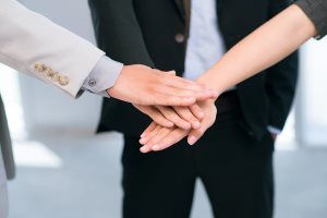 Business people putting their hands together in sign of trust and unity