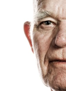 Elderly man's face over white background