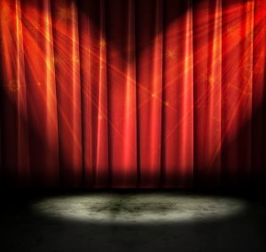 Red curtains on a stage with sparkly lights