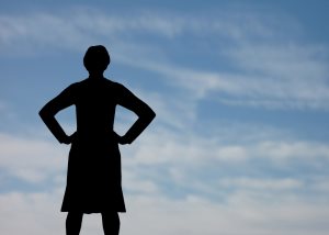 Assertive female silhouette against blue sky