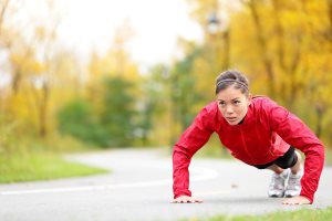 crossfit woman doing push-ups during outdoor cross training workout