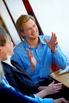 male smiling and talking with friends