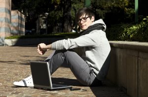 portrait of young man with his laptop, outdoors
