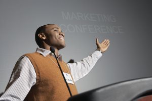 African American businessman giving a speech on podium