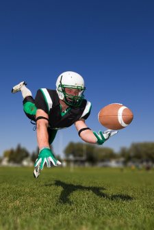 American football player diving and catching the ball