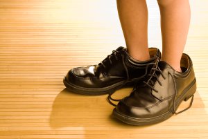 Big shoes to fill child's feet in large grown-up black shoes