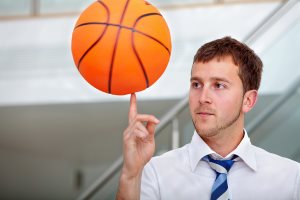 Business man playing with a basketball at the office
