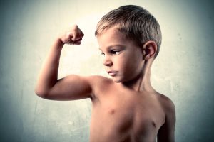 Portrait of a child showing the muscle of his arm