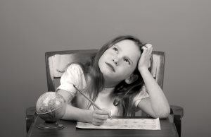 Young Girl Doing Schoolwork Looking Thoughtful or Distracted