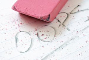 pink eraser on paper with partially erased word - 'oops'