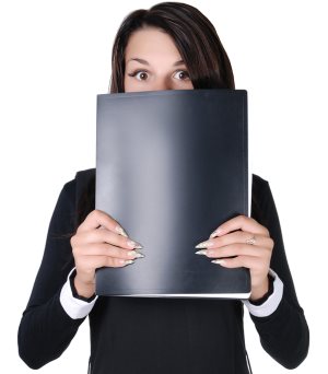  Young frightened business lady hiding behind black folder