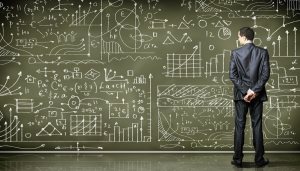 Business person standing against the blackboard with a lot of data written on it