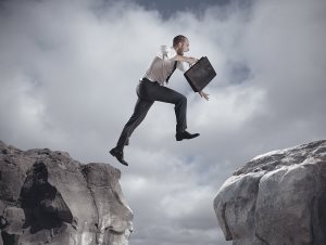 Businessman Jumping Over The Mountains