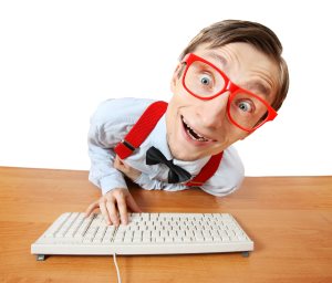 Geek at computer wearing red glasses
