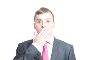 Shocked businessman with hands over his mouth