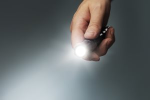 Man holding a small but powerful led flashlight 