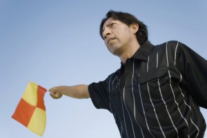 Low angle view of a soccer referee showing offside flag