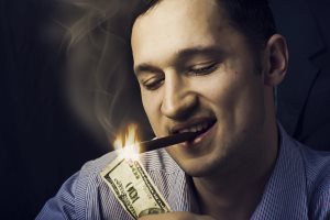 Man Lighting His Cigar With $100 Bill
