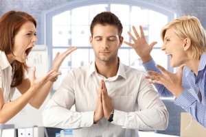 Meditating closed eye businessman in office with arguing colleagues 