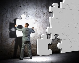 businessman compiling macro white puzzle