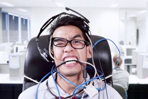 Businessman Biting Cables At Office