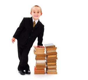Little business man next to a stack of books