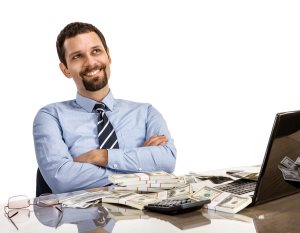 businessman at his desk with laptop and a lot of money