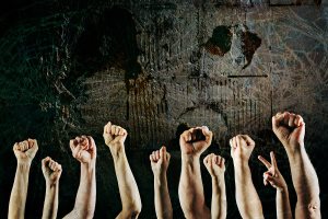 Arms raised in protest on a grunge background