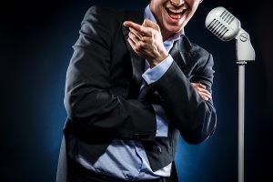 Businessman singing on microphone