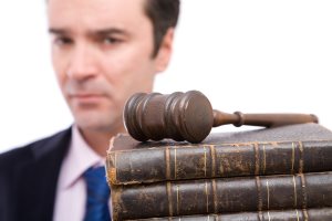 businessman holding gavel and law books