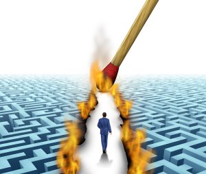 businessman walking through a complicated maze opened up by flames and fire lit by a match 