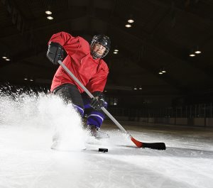 hockey player sliding kicking up ice