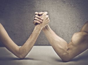 muscular man playing arm wrestling with a skinny one