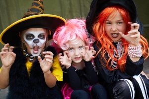 three Halloween girls looking at camera with frightening gesture