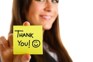 Business woman showing a post-it to thank you