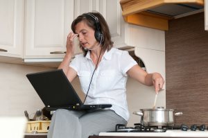 business woman having work conference call from home while cooking meal