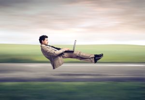 levitating businessman on a road using a laptop