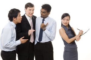 three businessmen talk about a female colleague behind her back